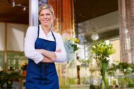 Woman standing smiling with arms folded, looking confident